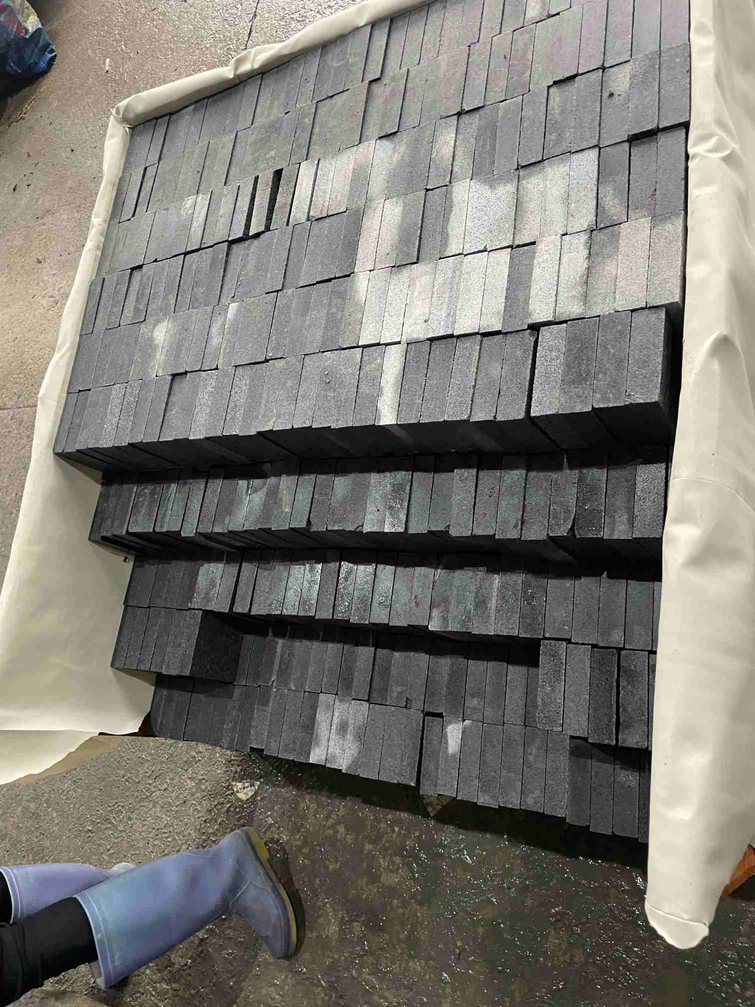 Granite paving unit with a flamed top and machine-cut side faces for outdoor paving.