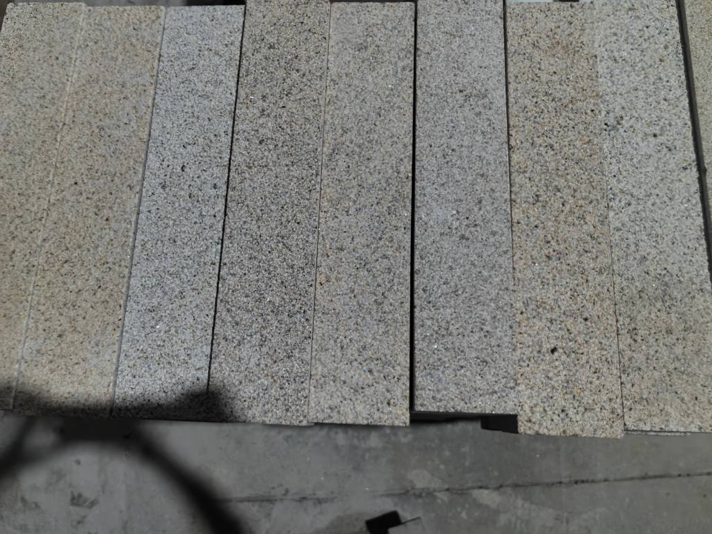 Granite paving zones combining regular pavers and contrasting finishes in a public plaza.