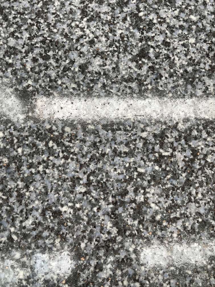 Polished Jiangxi Blue Crystal granite showing a darker reflective face and clear mineral detail.