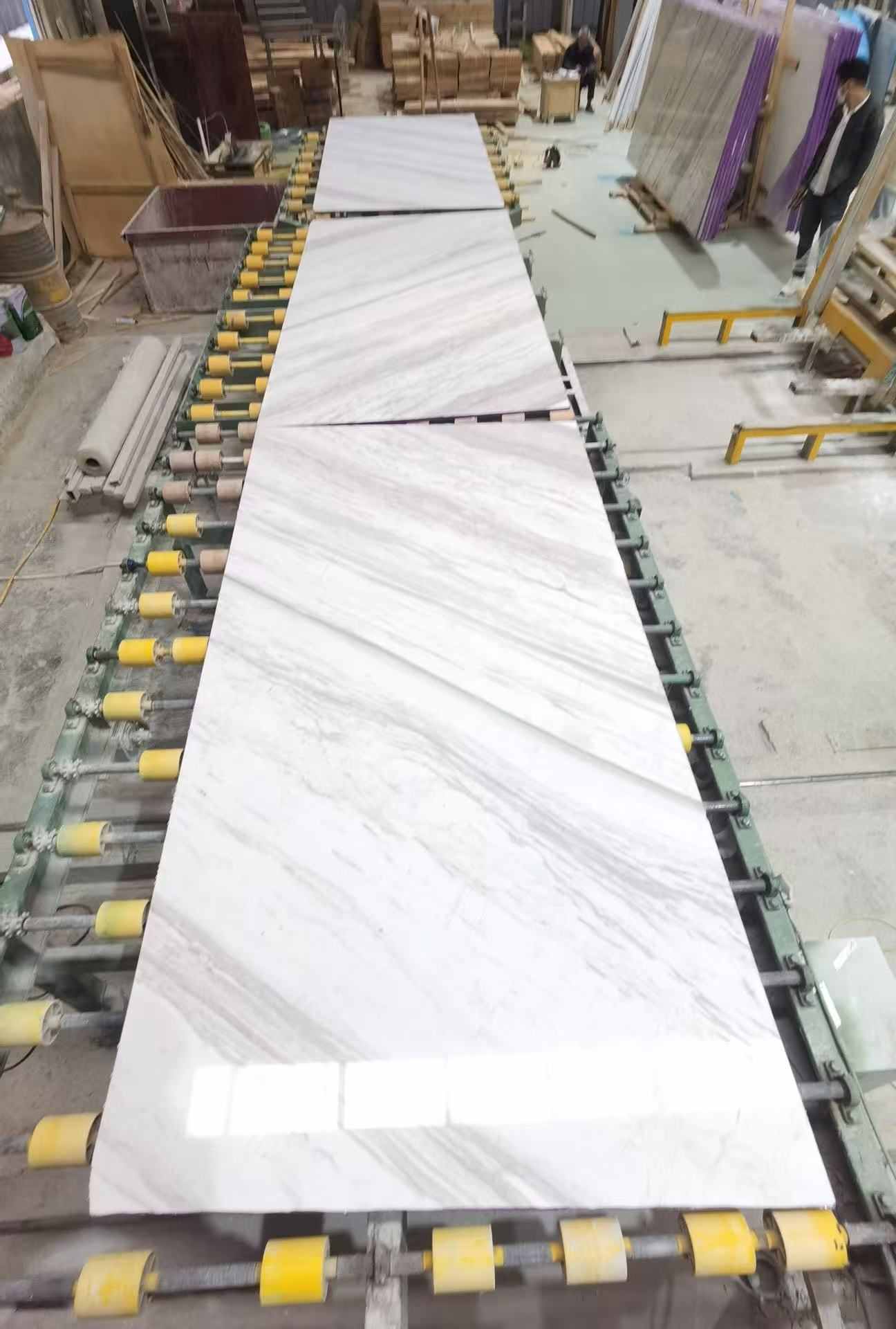 Volakas marble slabs arranged on a factory production line for batch and vein inspection