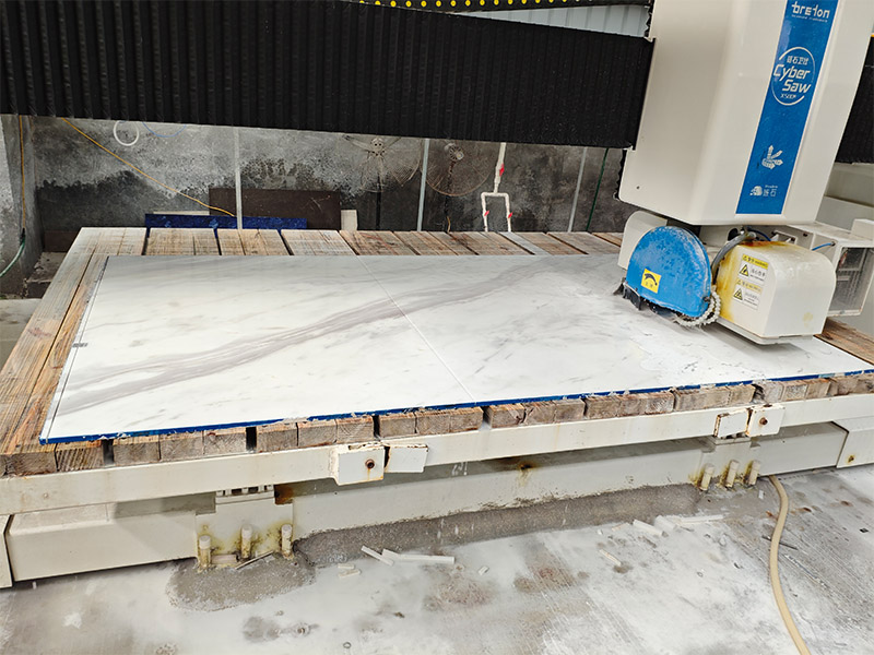 Automatic saw cutting Volakas marble into repeated rectangular tile sizes