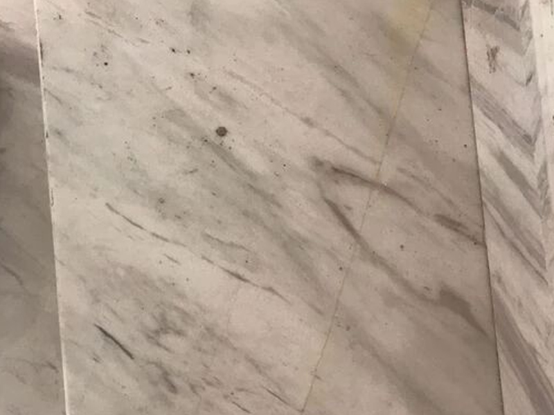 Volakas Marble Surface - Fine Veins and Natural Mineral Marks Close-up of Volakas marble with fine grey linear veining and natural mineral marks