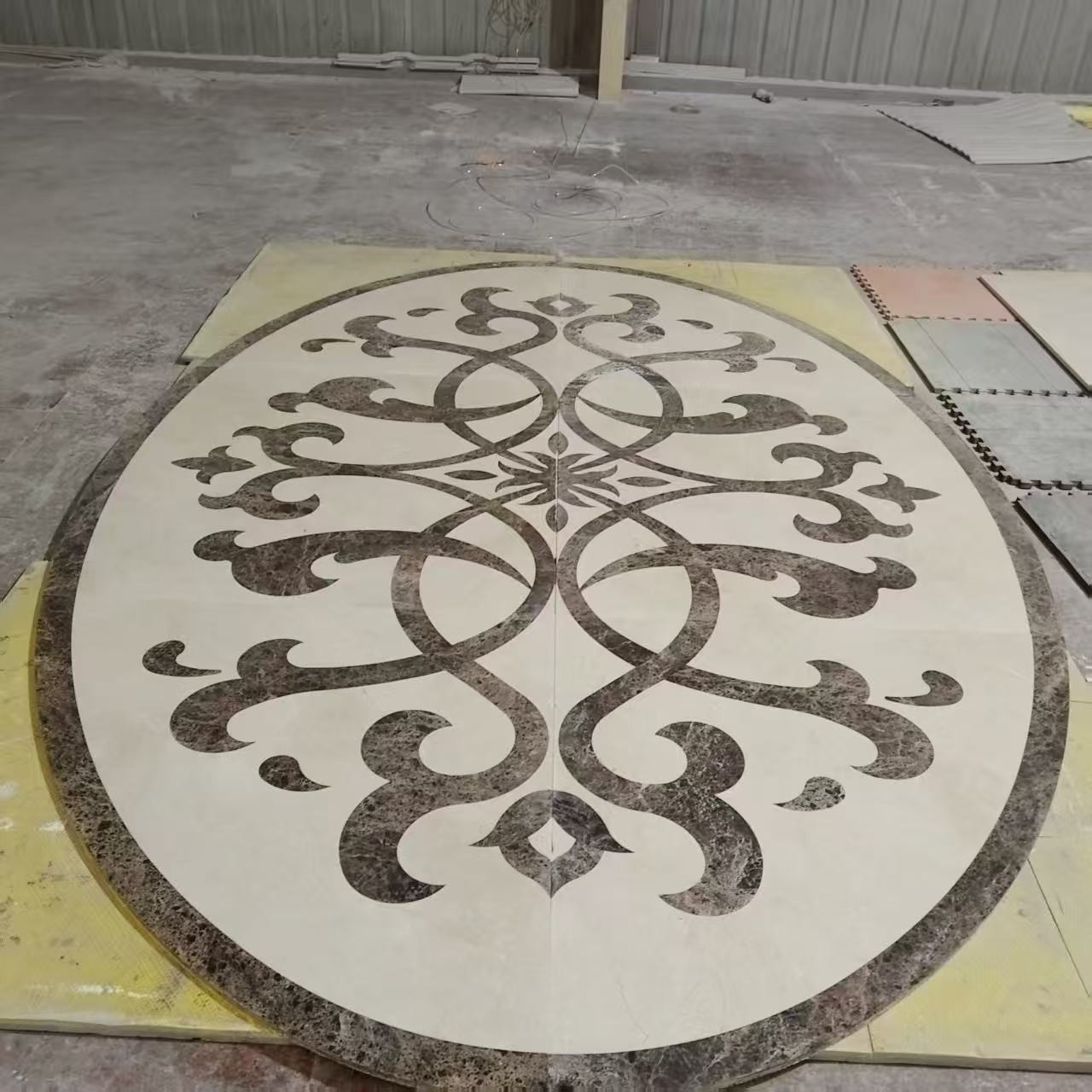 Oval waterjet marble medallion with symmetrical scrollwork produced by Excellent Stone