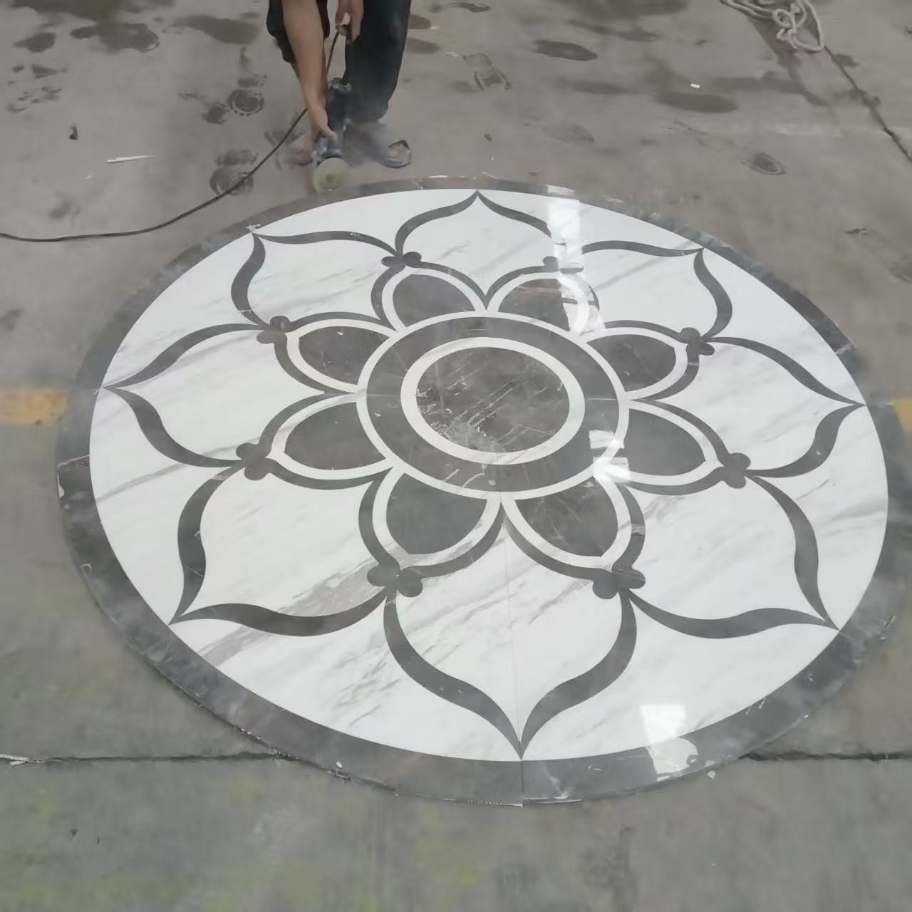 Black and white circular waterjet marble medallion with floral geometry